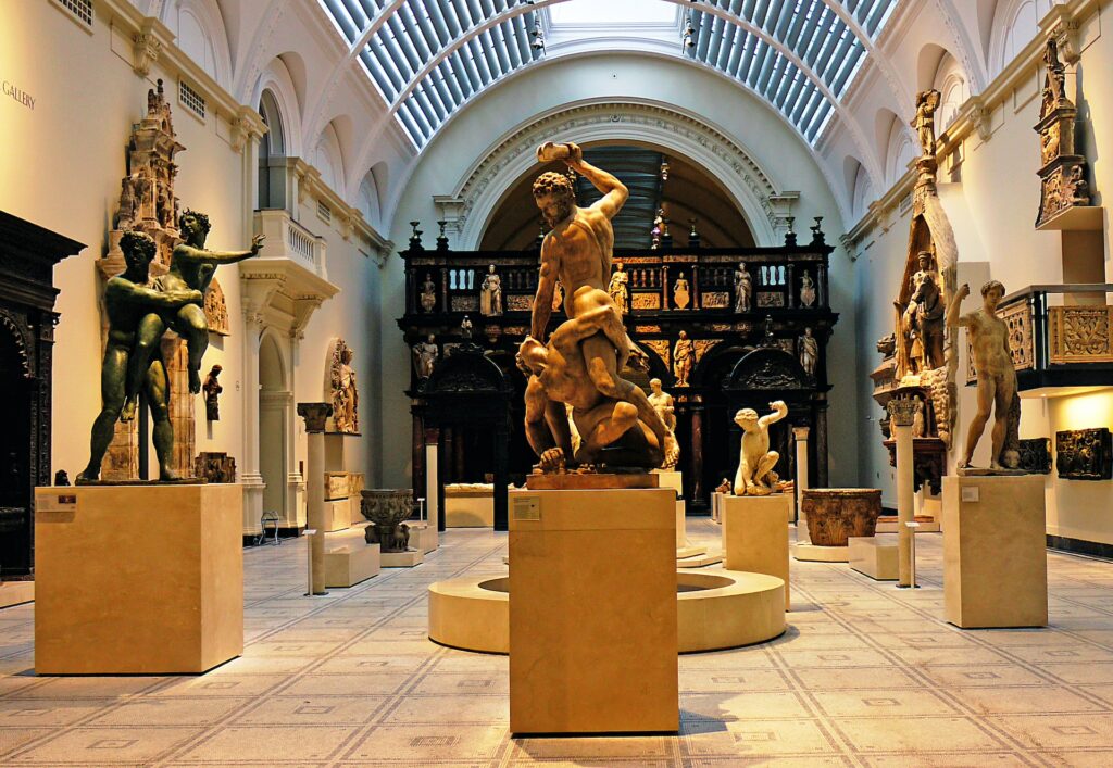 A museum gallery, filled with a display of classical sculptures.