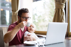 Man working at a café with his child, showing flexible benefits in a talent acquisition strategy.
